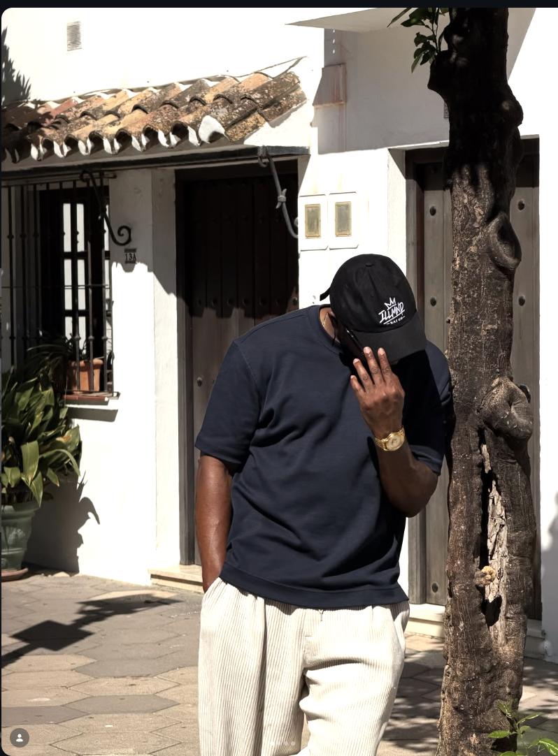 Black Genesis cap worn on a sunny street