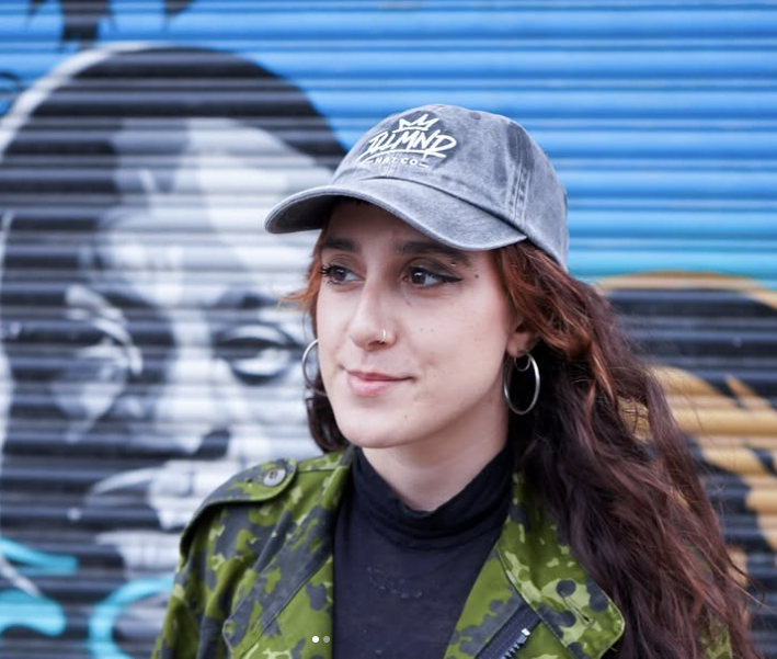 Washed Genesis cap worn in front of a painted shutter